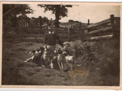 Photo of a visitor with Edwin, sheepdog and a lamb.  Picture is marked on back simply with 'Hoar Oak X Pens' indicating this photo is mainly to show the extensive sheep pens at the cottage.
