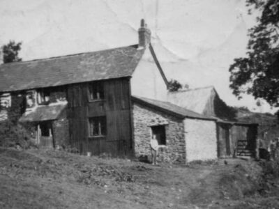 Hoar Oak Cottage in the 1950s when Abe and Gert Antell lived there. Note black (tarred) corrugated iron cladding. A method for trying to reduce the internal damp.  Photo courtesy of Sandra Hughes.
